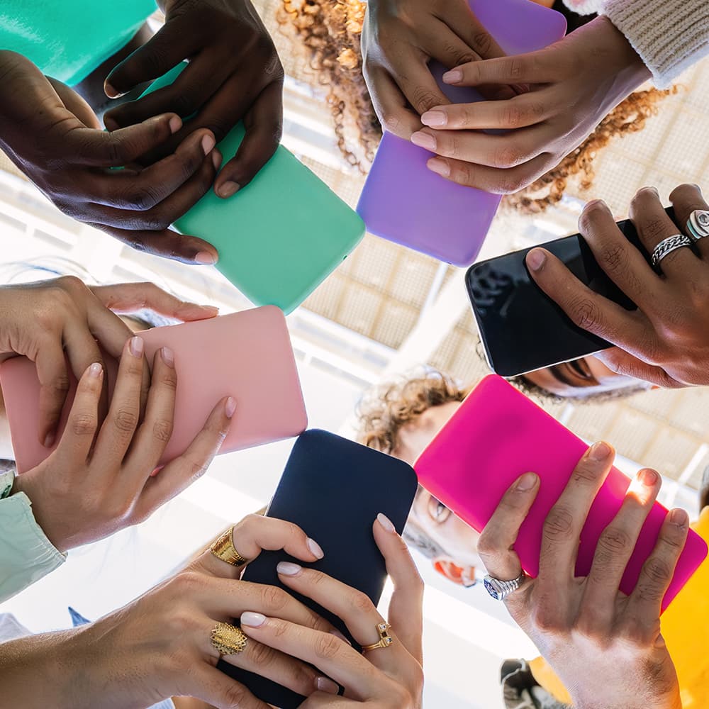 View from below of a circle of people using smartphones