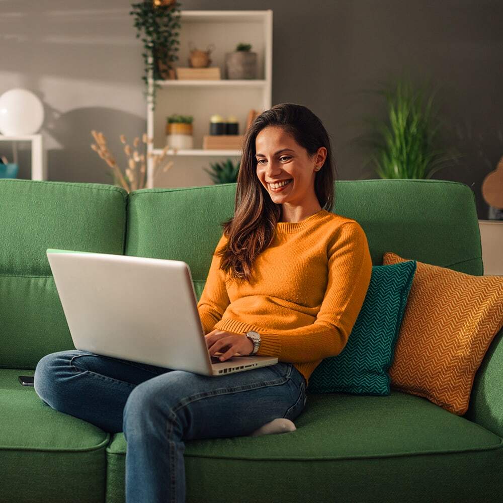 Person browsing on a laptop on a comfortable couch